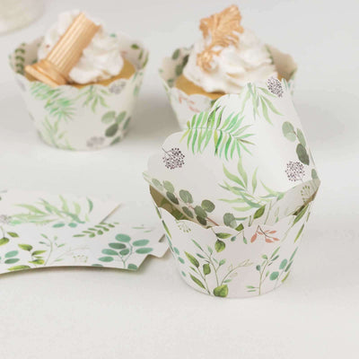 Decorative cupcake wrappers with green botanical prints on a white background.