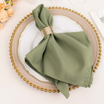 Green napkin elegantly draped on a plate with a decorative gold ring.