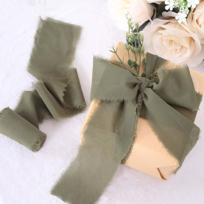 Olive green fabric ribbon elegantly tied around a gift box with flowers.