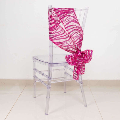 Transparent chair with pink sequin bow decoration.