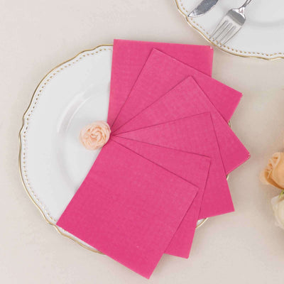 Pink napkins arranged on a decorative plate with a rose accent.