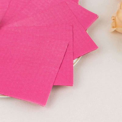 Pink square paper sheets arranged on a plate.
