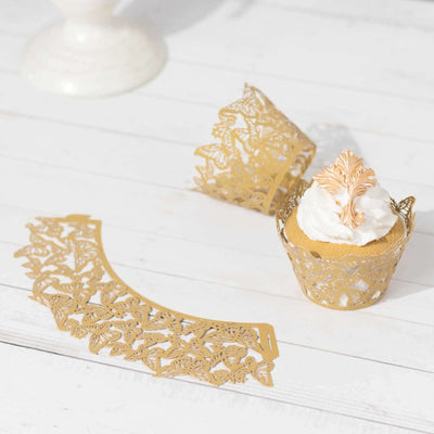 Gold lace cupcake wrappers and decorative collar on a white wooden surface.
