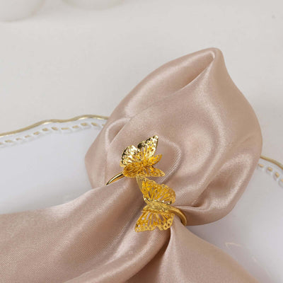 Gold butterfly napkin ring on a satin napkin.
