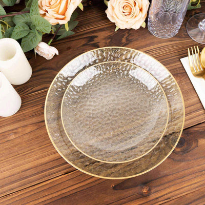 Elegant textured glass plate with gold trim on a wooden table setting.
