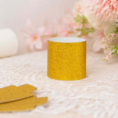 Gold glitter paper cup on lace tablecloth with flowers in the background.