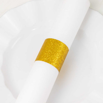 Gold glitter napkin ring on a white plate.