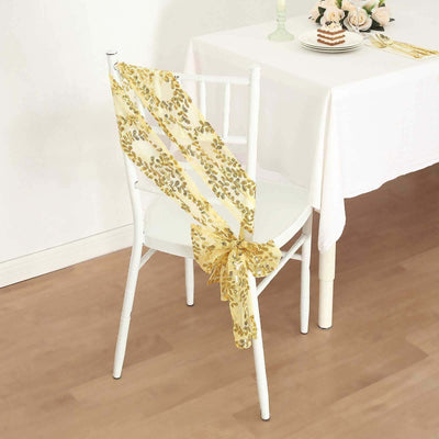 Yellow decorative chair sash tied on a white chair in a dining setting.