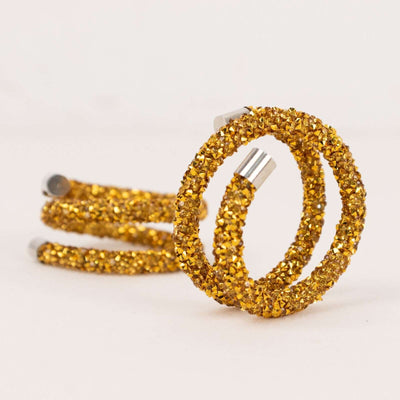 Gold glitter hair ties on a white background.