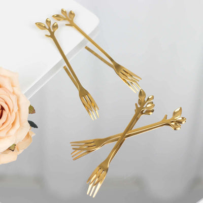 Gold leaf design appetizer forks on a white background