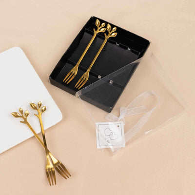 Gold leaf design dessert forks in a gift box with a clear sleeve.