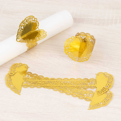 Gold heart-shaped napkin holders on a light wooden surface.