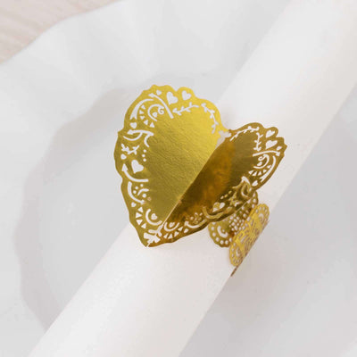 Gold heart-shaped napkin ring on a white background.