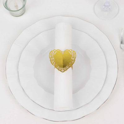 Gold heart napkin ring on a white plate setting.