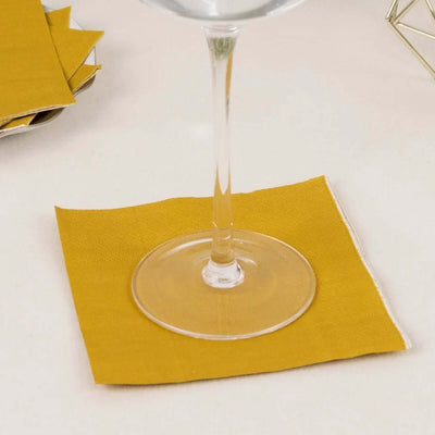 Yellow cloth napkin under a wine glass on a light surface.