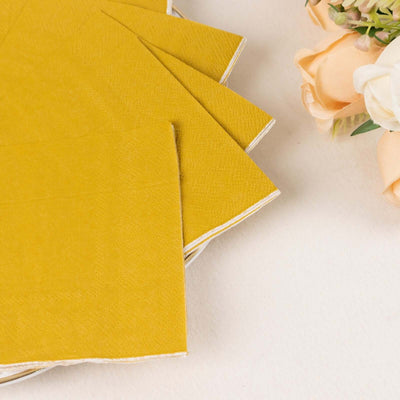 Yellow paper napkins stacked elegantly on a plate with flowers.