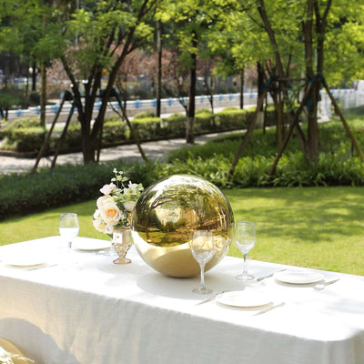 Gold decorative sphere centerpiece on an outdoor dining table.