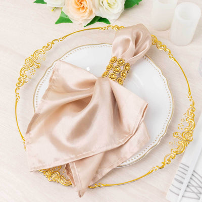 Elegant satin napkin with jeweled ring on ornate plate.
