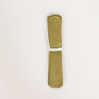 Green paper straws bundled together on a plain background.