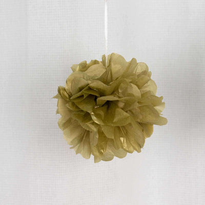 Gold tissue paper pom pom decoration hanging on a white background.