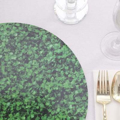 Green leafy round placemat on a white table setting with silverware.