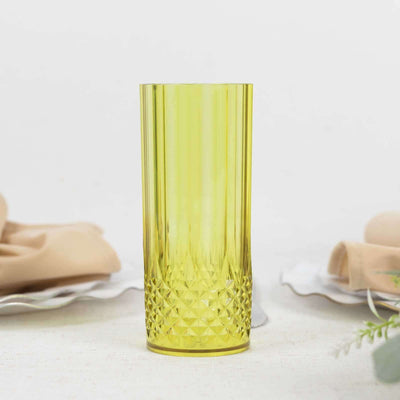 Yellow ribbed glass tumbler on a plain surface