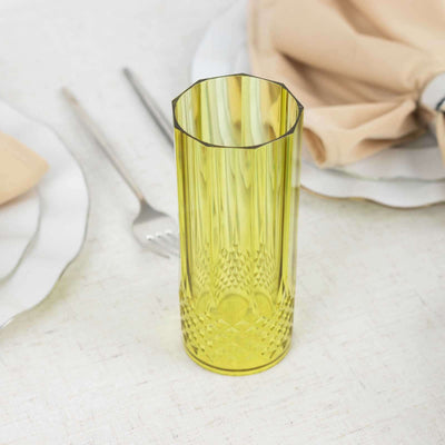 Yellow glass vase with textured design on a dining table.