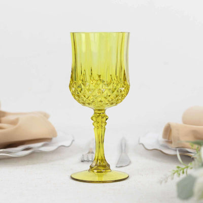 Yellow crystal goblet with intricate design on a white background