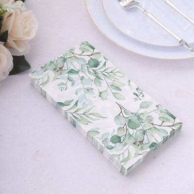 Floral patterned napkins with green leaves on a plain background.