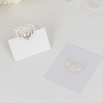 Elegant white place card and matching invitation with intricate heart design.