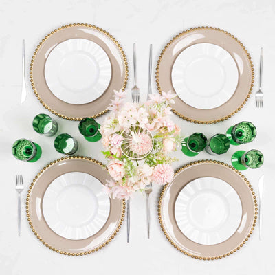 Elegant dinner table setting with gold-beaded plates and green glassware.