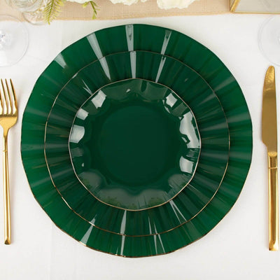 Elegant green dinner plates set with gold accents on a white tablecloth.