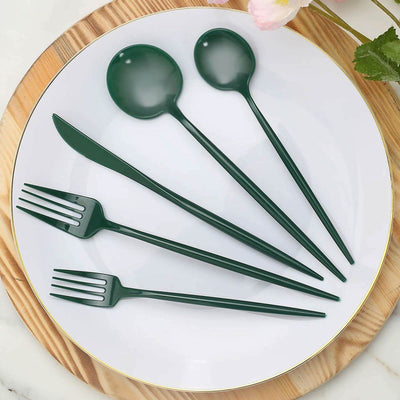 Green plastic cutlery set on a white plate