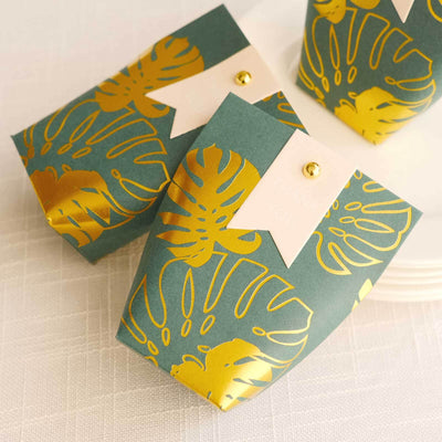 Gold-foiled tropical gift boxes with "Thank You" tags on a light background.