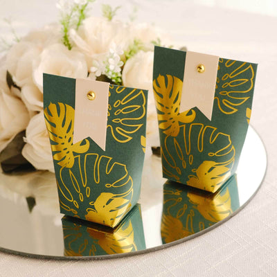 Thank you gift boxes with gold leaf design on a reflective surface.