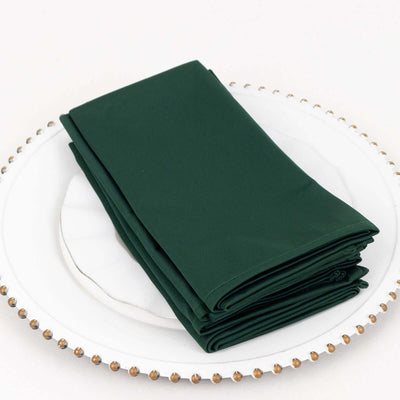 Green fabric napkins neatly folded on a decorative plate