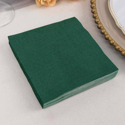 Green paper napkins stacked neatly on a table.