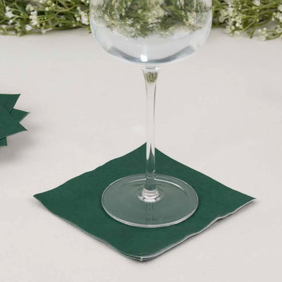 Green paper coaster under a wine glass on a light surface