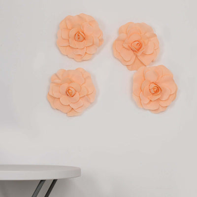 Peach paper flowers on a wall above a table