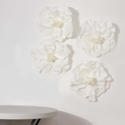 White decorative paper flowers on wall above a round table.