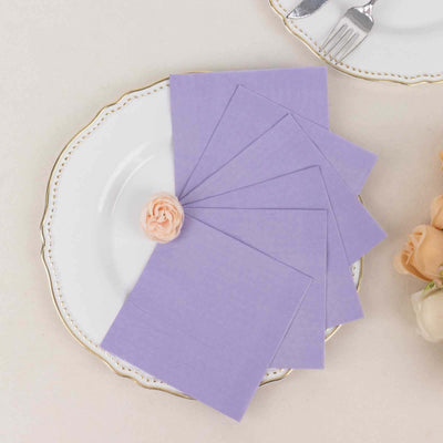 Purple napkins arranged on a decorative plate with a flower accent.