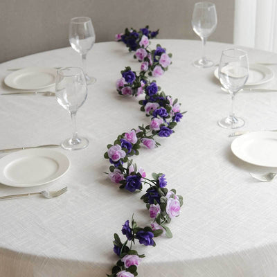 Floral table runner on a dining table set with plates and glasses.