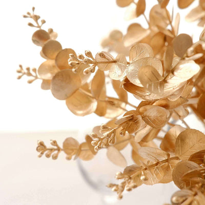 Gold leaf floral arrangement in clear vase, showcasing intricate details.