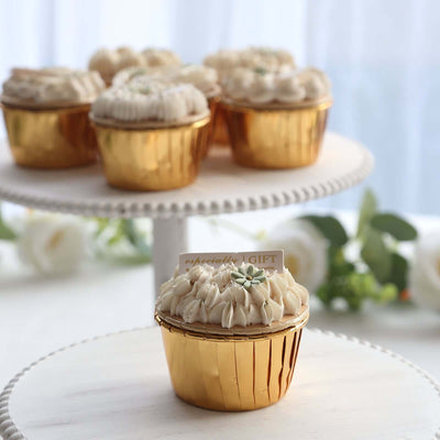 Golden cupcake with creamy frosting and decorative flower on a cake stand.