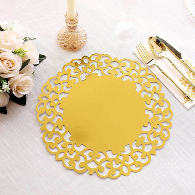 Gold decorative charger plate on a white table with flowers and cutlery.