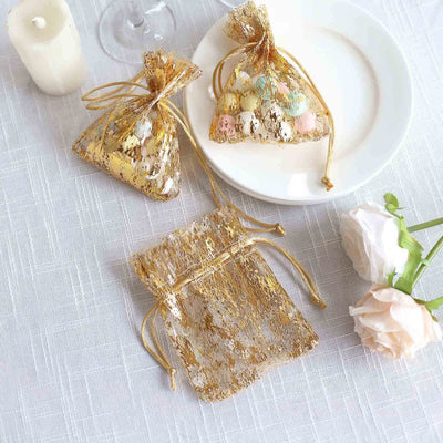 Gold organza bags filled with colorful candies on a table.