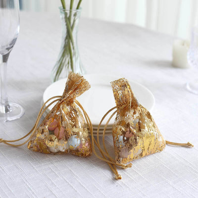 Golden gift bags filled with colorful treats on a dining table.