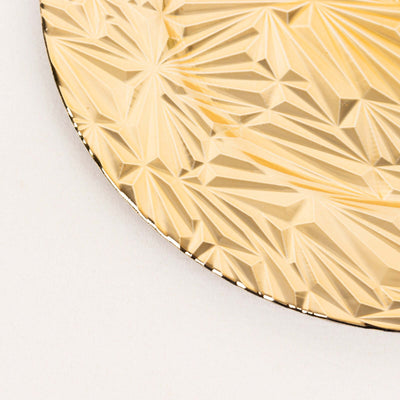 Gold decorative plate with intricate geometric design.