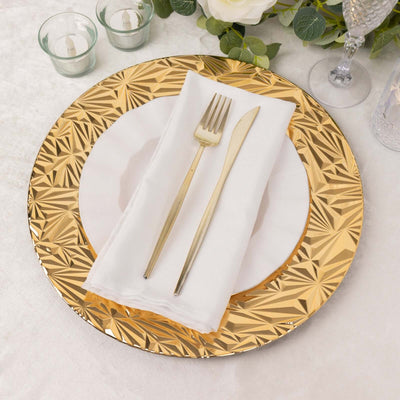 Elegant gold charger plate with white napkin and silver cutlery on a table setting.