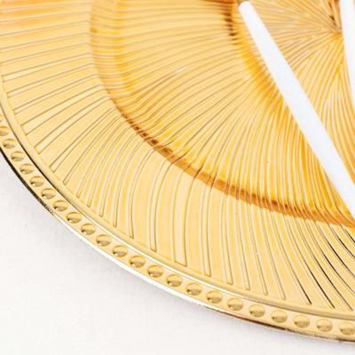 Gold decorative plate with textured design and white accents.